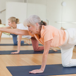 Older woman doing yoga in a fitness classroom