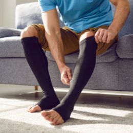 Man pulling up compression stocking