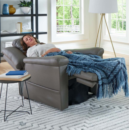 Woman napping reclined in grey leather lift chair in her home
