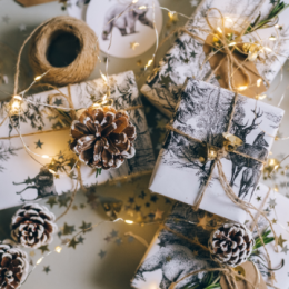 Stack of wrapped gifts with twine, acorns and fairy lights around them