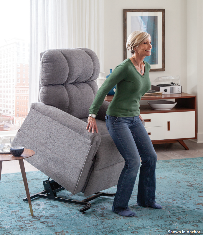 Woman standing up and out of a fabric grey lift chair